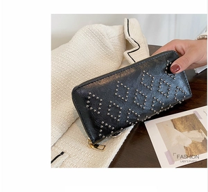 Detailansicht der schwarzen Leder-Clutch mit silbernen Nieten und goldenem Reißverschluss