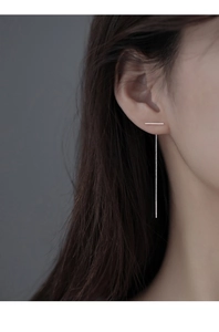 Close-up of a long minimalist S999 sterling silver T-shaped threader earring on a model