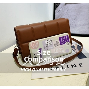 Detailed view of brown quilted crossbody bag size comparison with a smartphone