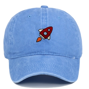 Close-up of rocket embroidery on washed blue cotton baseball cap with textured details
