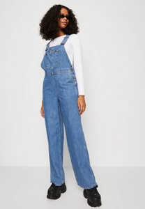 Detail of blue denim dungarees with front pocket and adjustable straps in retro style