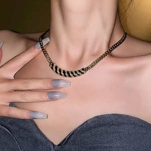Dettaglio macro di una collana vintage placcata in oro con smalto nero e cristalli