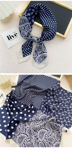 Close-up of navy blue silk-like scarf featuring classic polka dots and paisley patterns