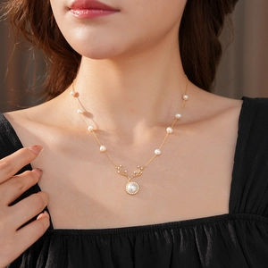 Dettaglio di una collana vintage con corna di cervo, perle e zirconi su una modella