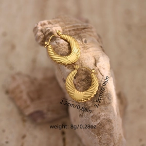 Detailed size view of fan-shaped gold earrings with ripple texture on stone base
