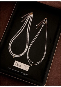 Detail of freshwater pearl necklace set with 14K gold plated clasp on black velvet