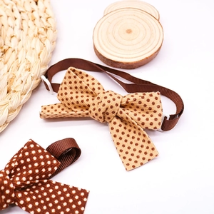 Detailed fabric texture of brown polka dot pet bow ties with adjustable straps