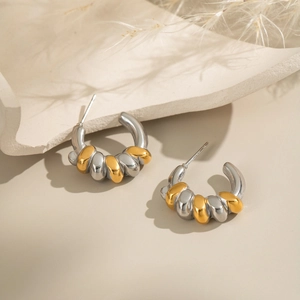 Twisted two-tone geometric hoop earrings in gold and silver finish with spiral texture