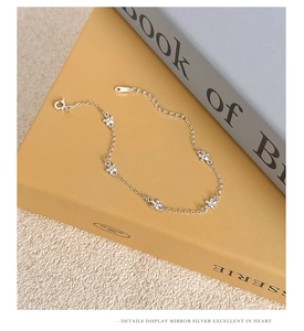 Detailed view of silver flower bracelet with five petals on a book background