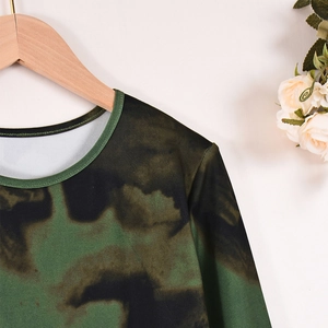 Détail d'une robe tie-dye vert et noir à col rond et manches longues sur un cintre