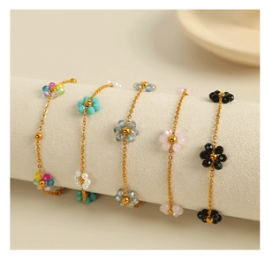 Detail of colorful beaded flower bracelets with delicate gold link chains for women