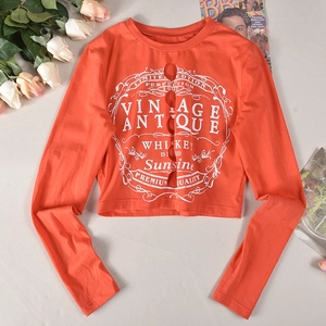 Detail eines orangefarbenen Langarmshirts mit Cut-Out-Design und Vintage-Grafikdruck