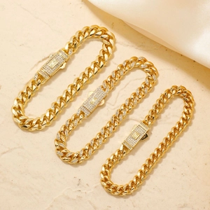Drei Reihen goldene Panzerketten-Armbänder mit glitzernden Zirkonia-Verschlüssen