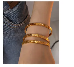 Detailed view of polished 18K gold plated bangles featuring zircon star engravings