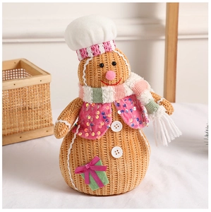 Close-up of knitted gingerbread man doll with sequin vest and chef hat for Christmas decor