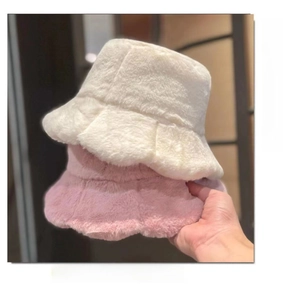 Detail of soft faux fur bucket hats in beige and pink with warm plush wavy brims