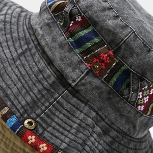 Detailed macro view of vintage washed grey fabric with ethnic woven band and copper snap