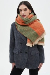 Detail of orange and green striped bouclé scarf with soft fringe texture on model