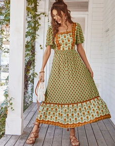 Detail of square neck floral maxi dress with bohemian print in green and orange tones
