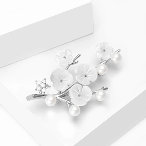 Détail de broche fleur de prunier élégante avec perles d'eau douce et zircons brillants