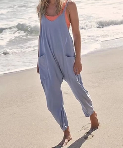 Detail of light blue loose jumpsuit with large pockets on an outdoor beach setting