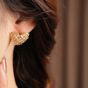 Gros plan de boucles d'oreilles cœur plaqué or 18 carats avec zircone sur modèle