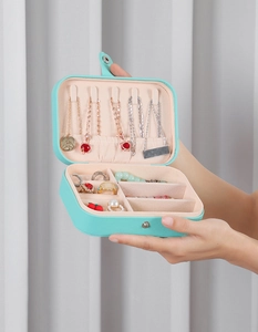 Close-up of portable jewelry box with necklace hooks and rings storage compartment