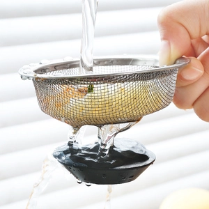 Stainless steel kitchen sink strainer being rinsed under running water for debris filtration