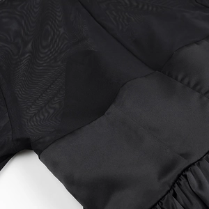 Gros plan sur les empiècements en résille noire et les coutures de la robe élégante