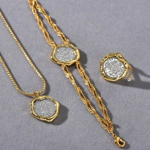 Detail view of vintage-style jewelry set with 18k gold plated coins and pearl ring