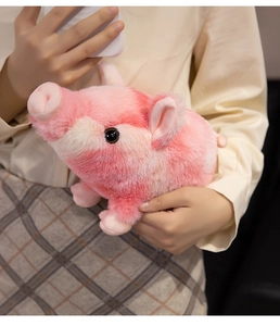 Gros plan d'un doudou cochon à rayures roses et beige tenu par un mannequin