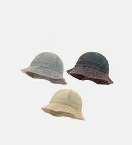 Détail de bobs en denim montrant les coutures du bord en bleu et beige