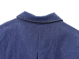 Dettaglio ravvicinato del colletto a rever e della trama denim blu scuro sul retro della camicia