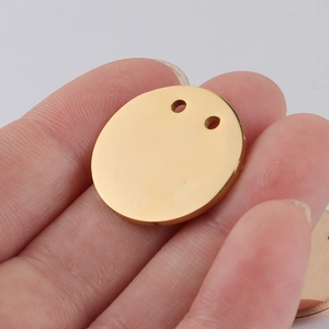Detailed macro view of 21mm golden double-hole round stainless steel pendant with mirror finish