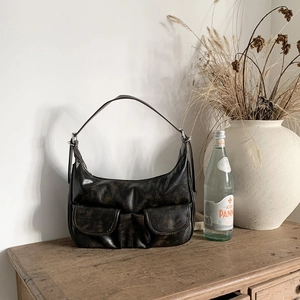 Detail view of vintage dark brown faux leather hobo bag with front flap pockets