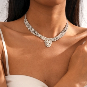 Détail macro du collier multi-rangs en strass avec pendentif goutte sur le mannequin
