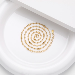 Elegant S925 sterling silver gold beaded necklace displayed in a white porcelain dish