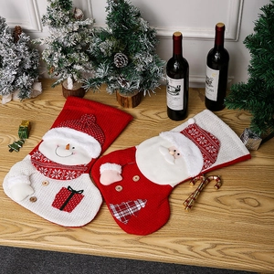 Large knitted Christmas stockings with Santa and snowman motifs in festive red and white setting