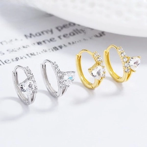 Macro shot of S925 silver and gold heart earrings with sparkling cubic zirconia pavé