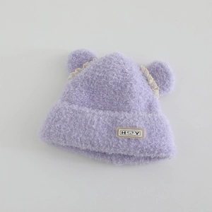 Detailed texture of purple plush knit hat with bear patch and white lace ears