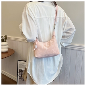 Détail du sac hobo rose clair à texture plissée et design de bandoulière nouée