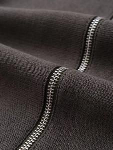 Macro detail of high-quality metal zipper on dark ribbed knit winter cardigan jacket