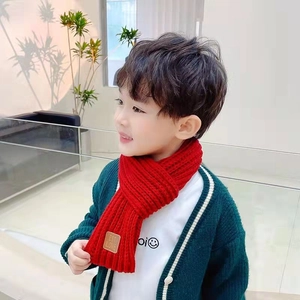 Close-up of a red knitted kids scarf made of soft cashmere-like material on a model