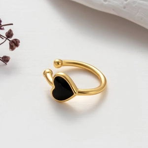 Elegant gold metal cartilage ear cuff featuring a black enamel heart on a white background