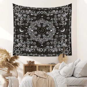 Detail of bohemian mandala tapestry featuring sun, moon, and floral line art in black and white