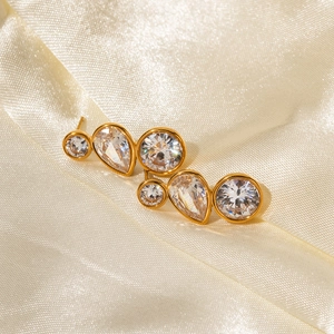 Gold plated stainless steel stud earrings with three clear zircons on beige silk
