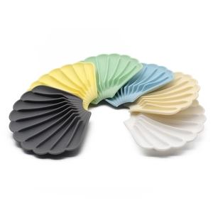 Macro shot of seashell-shaped silicone soap dishes in multiple colors with drainage