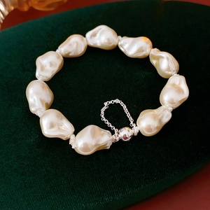 Close-up of Baroque pearl bracelet with magnetic ball clasp on dark green velvet