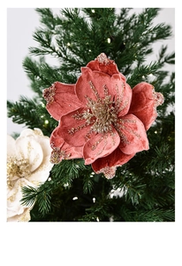 Pink velvet Christmas magnolia flower with gold sequins on dark green tree branch