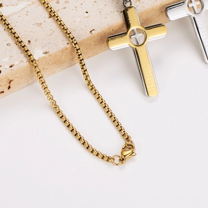 Polished stainless steel cross necklaces with prayer engraving on beige stone background
